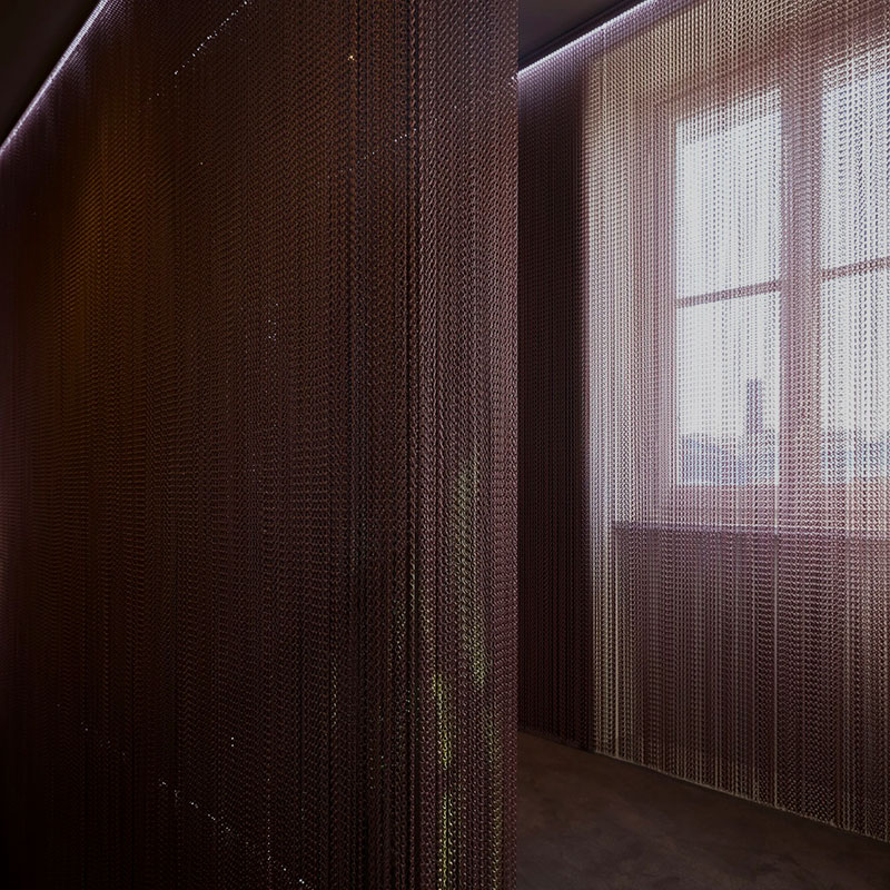 Aluchainor QKCLC aluminum chain link curtain used as a modern fly screen and decorative room divider in a home interior setting.