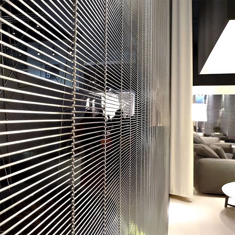 Woven wire drapery curtain panel made of decorative metal mesh used as a modern room divider or wall covering in architectural design.