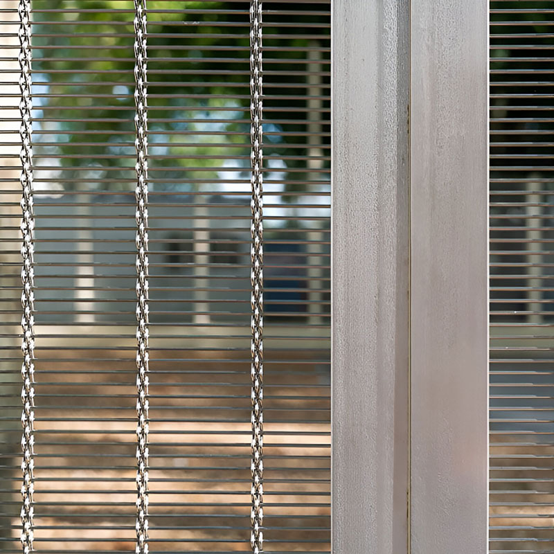 Woven wire drapery curtain panel made of decorative metal mesh used as a modern room divider or wall covering in architectural design.
