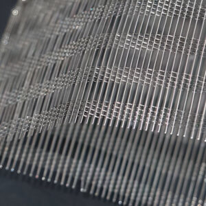 FibraMetis QKTH2 decorative wire textile applied on interior wall panel, featuring custom woven metal mesh in silver and bronze finishes