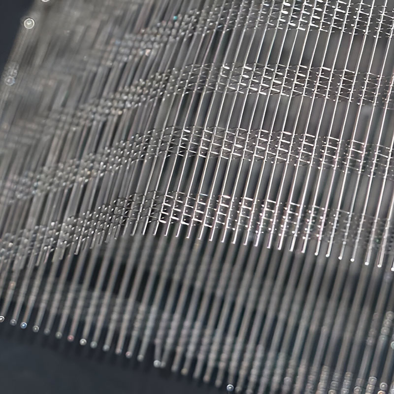 FibraMetis QKTH2 decorative wire textile applied on interior wall panel, featuring custom woven metal mesh in silver and bronze finishes