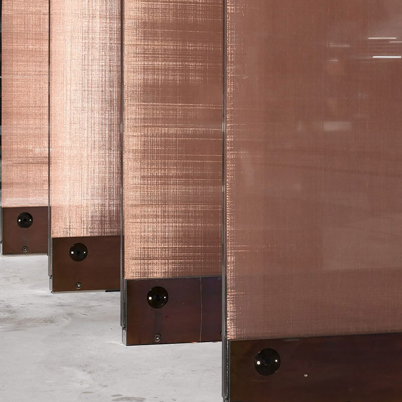 GlasMetis laminated wire mesh glass with metallic mesh layer, shown in custom finish for modern architectural use