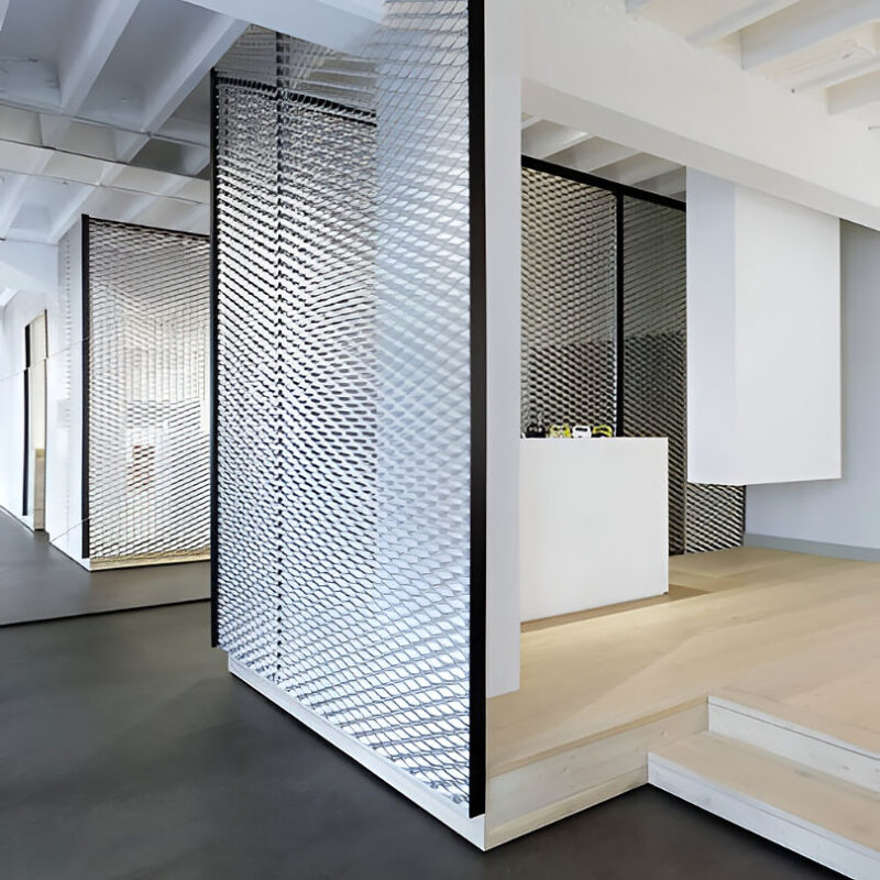 Expanded metal mesh panel with diamond-shaped openings used as architectural partition and facade feature.